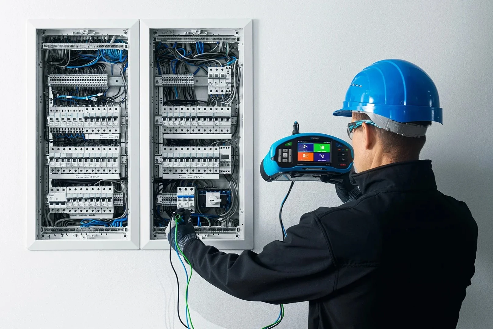 Das Foto zeigt einen Mitarbeiter vom E-Prüfwerk, welcher eine Anlagenprüfung / einen E-Check durchführt.